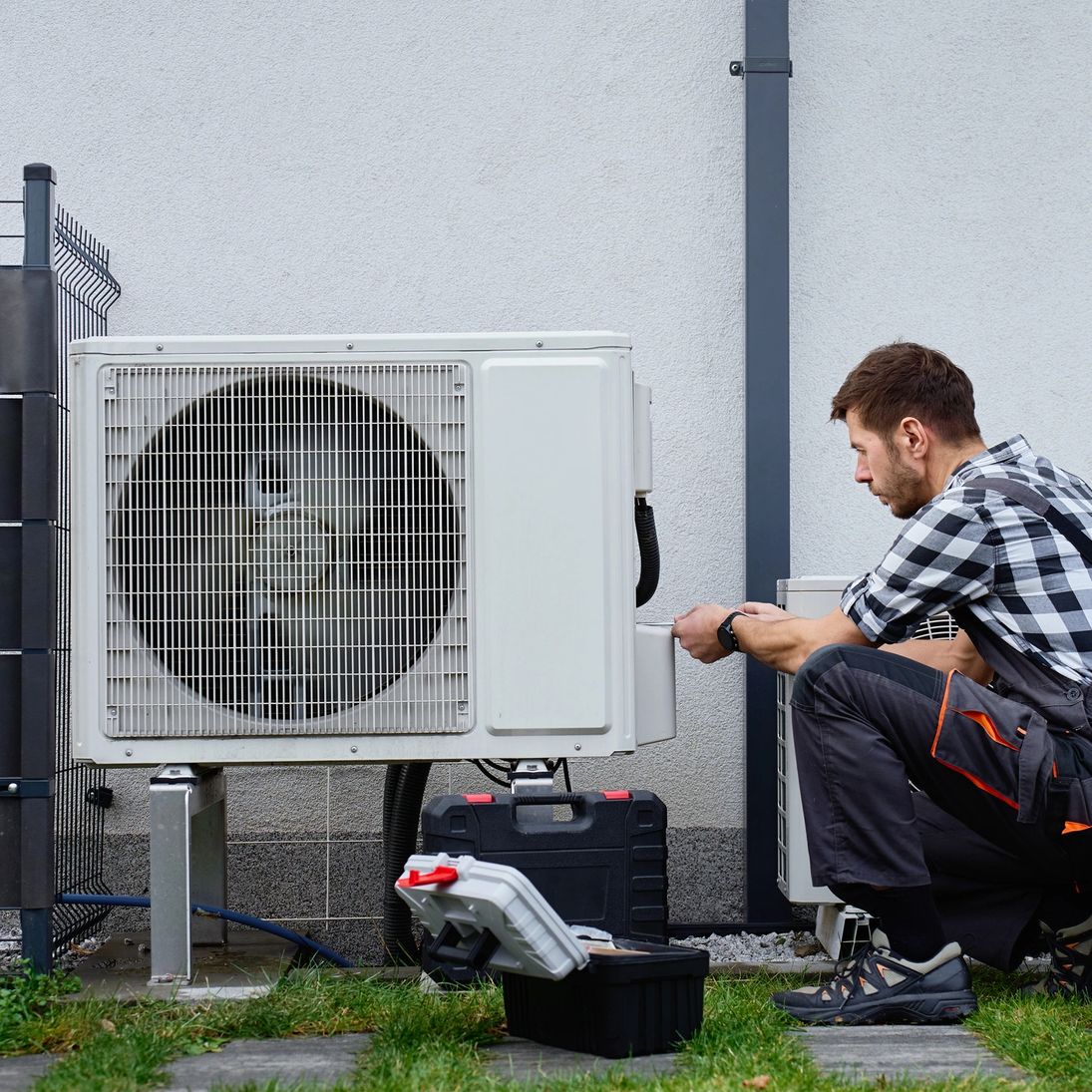Technician repairing an outdoor air conditioner unit